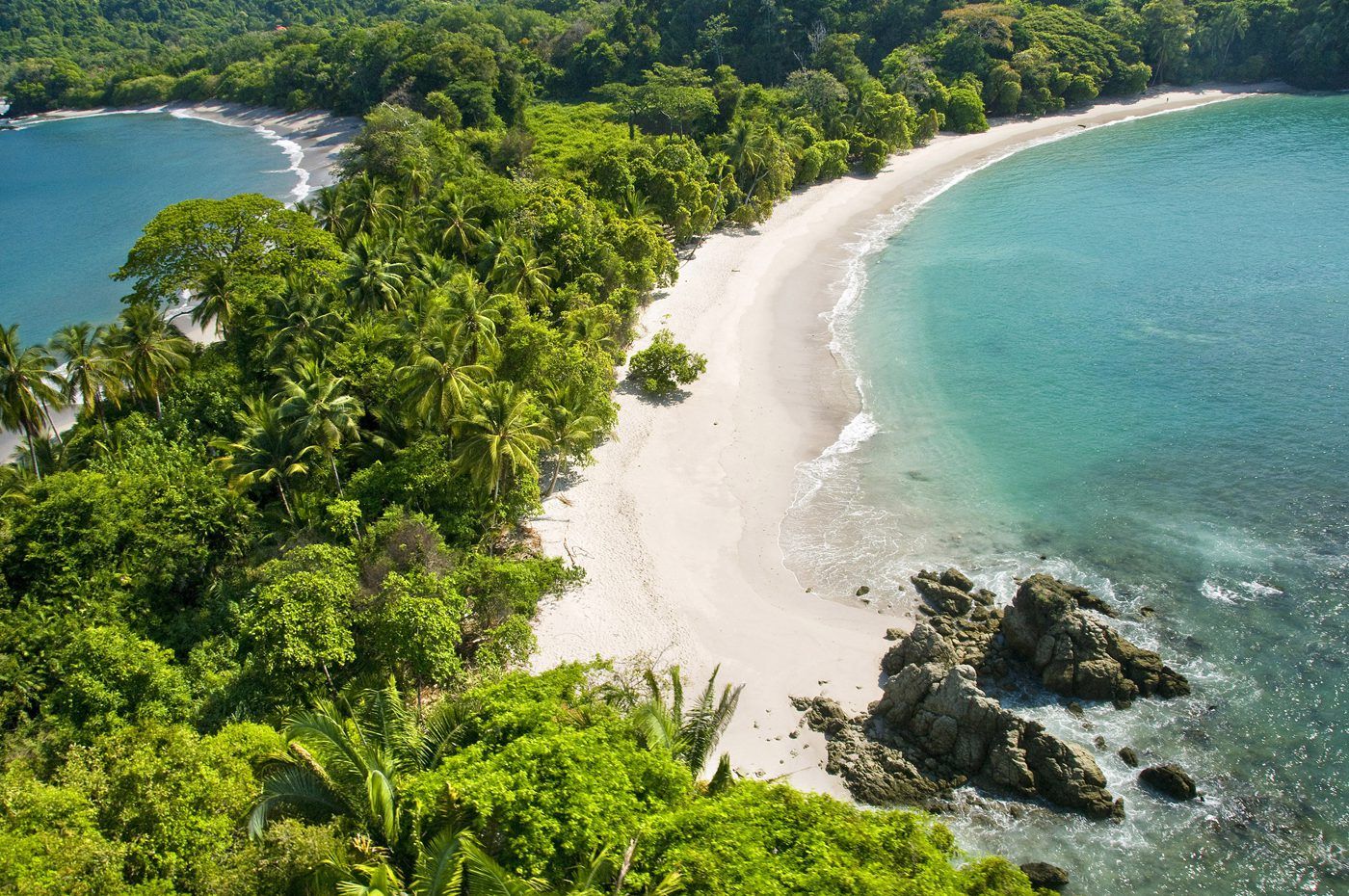 A panoramic view of Manuel Antonio National Park with beaches, forests, and wildlife.
