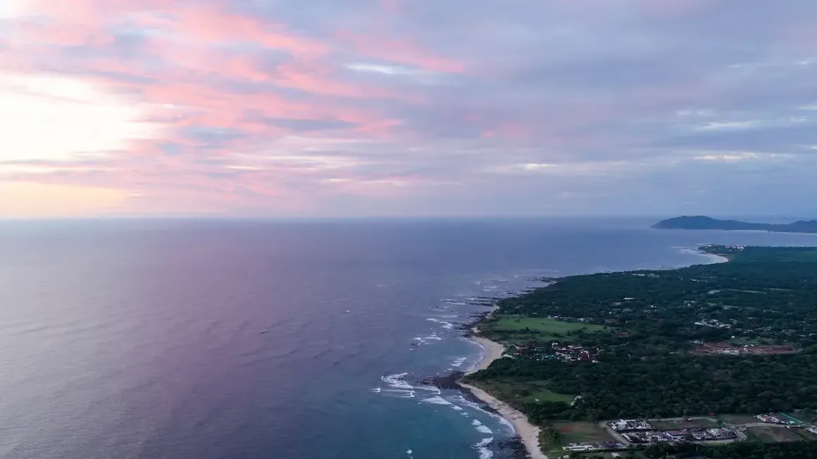 Aerial view of the Guanacaste coast at sunset with a long sandy beach and the calm Pacific Ocean