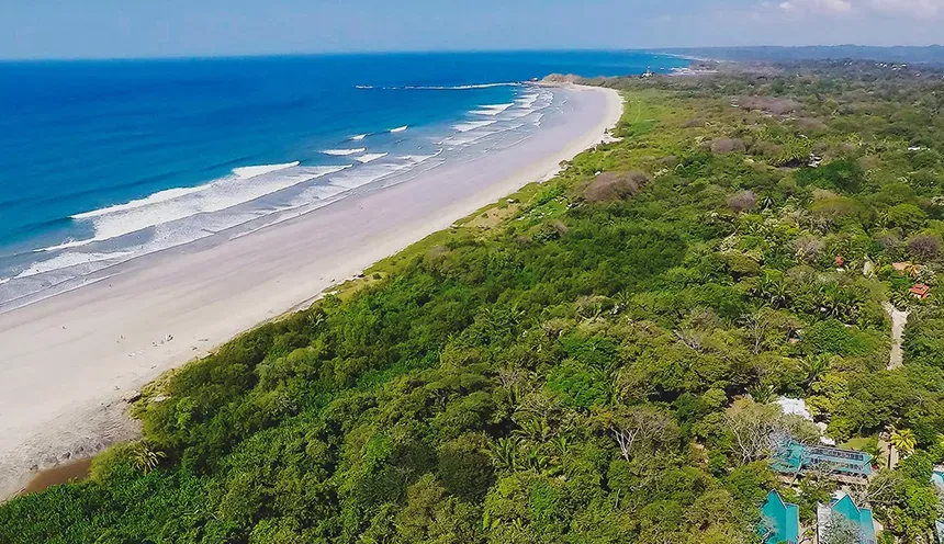 Aerial view of the pristine beach and surrounding greenery of Nosara, Costa Rica.