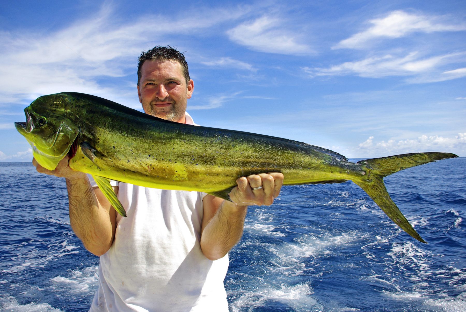 Angler with a mahi-mahi caught offshore in the South Pacific of Costa Rica