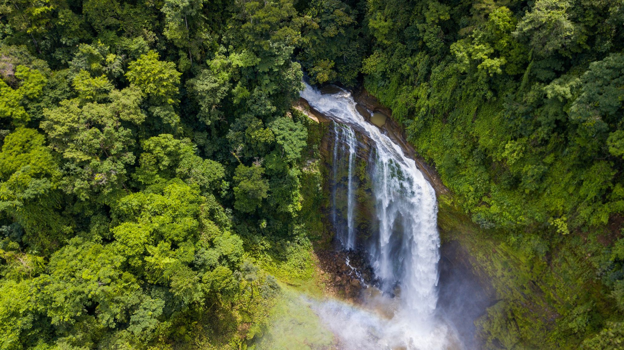 Aerial view of a waterfall cascading through Costa Rica rainforest