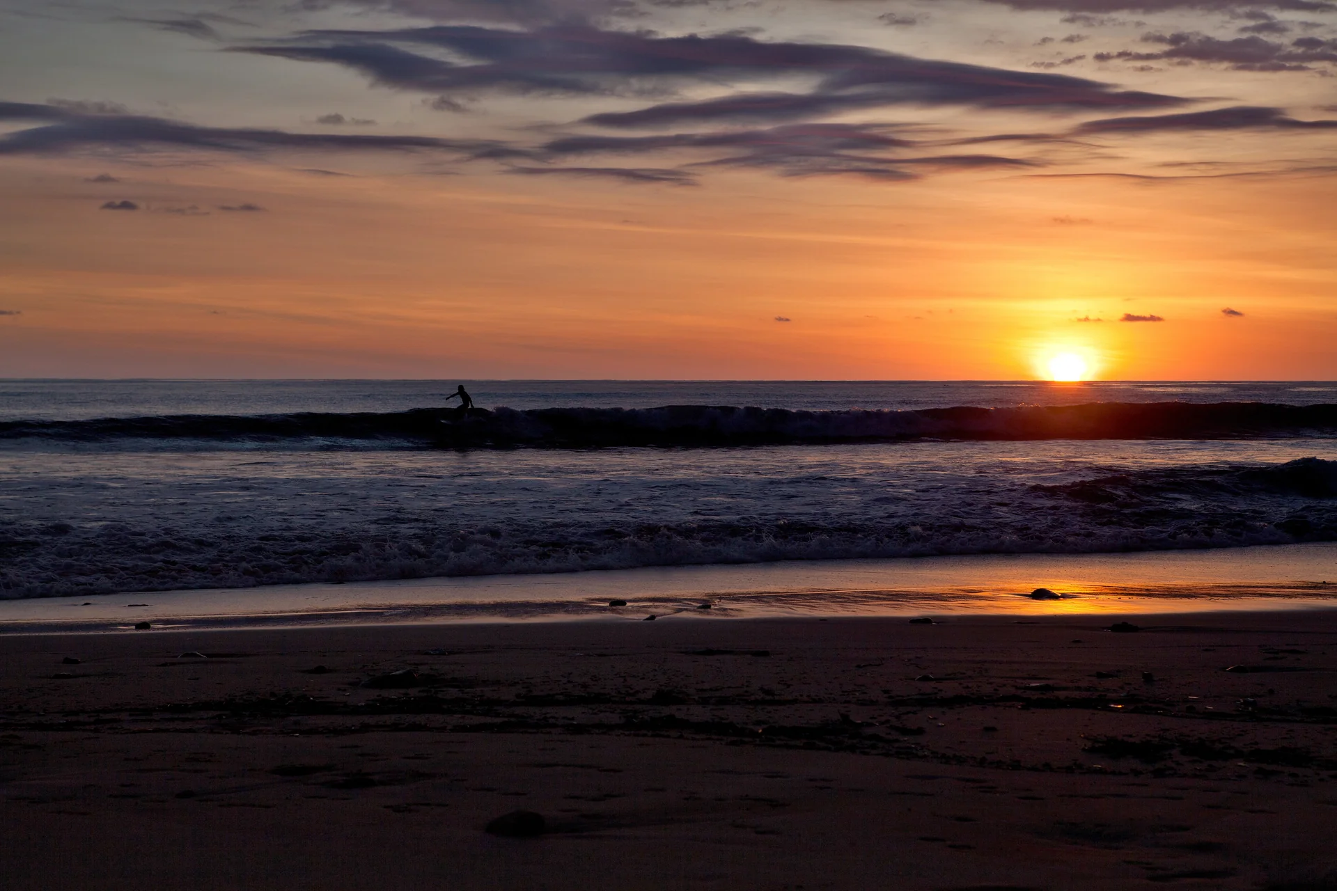 Surfers at Santa Teresa beach at sunset