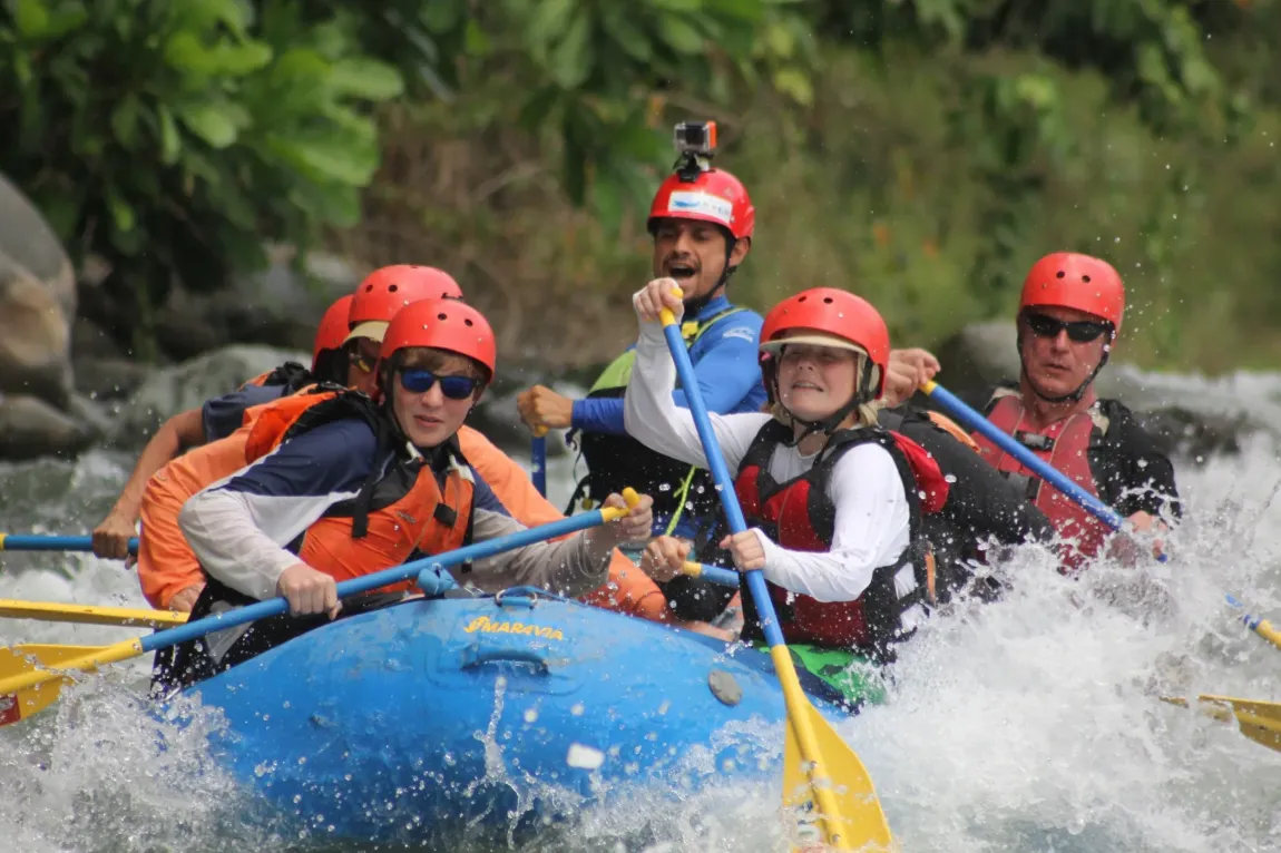 Famiglia in rafting con caschi e giubbotti di salvataggio su un fiume del Costa Rica