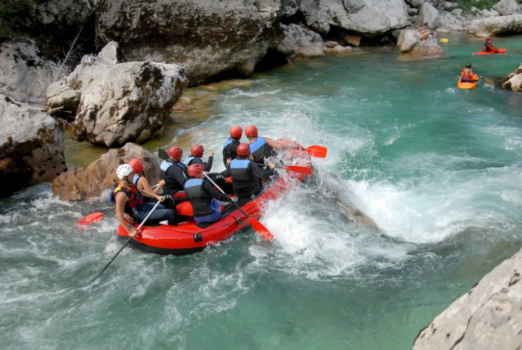 "Group of people navigating a rocky river, surrounded by rugged terrain."