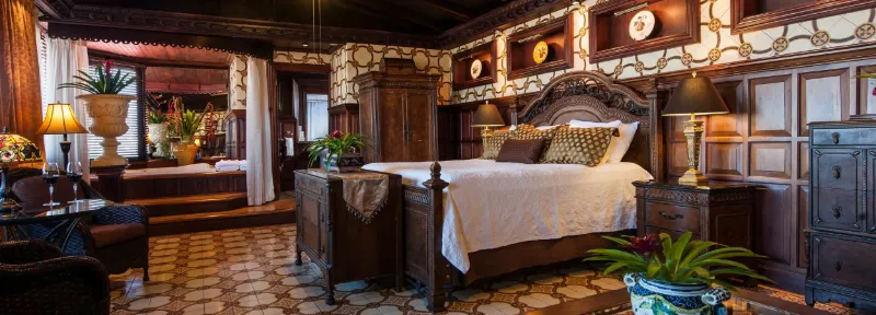 Camera tradizionale in legno con letto a baldacchino in un hotel boutique di San José