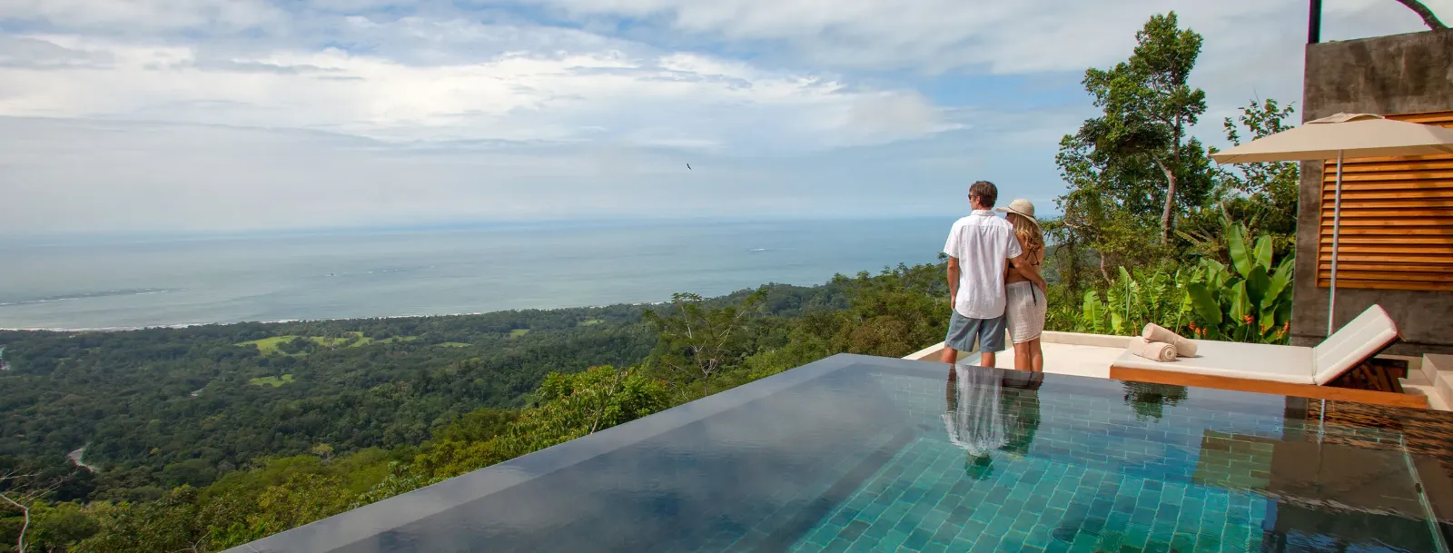 Coppia a bordo di una piscina a sfioro affacciata sulla costa pacifica del Costa Rica